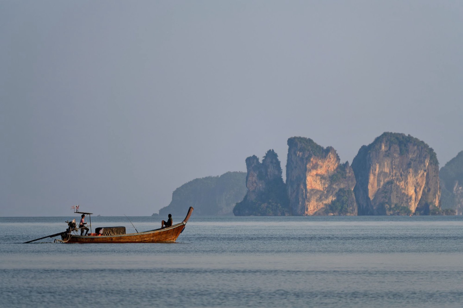 Una longtail boat davanti alle scogliere calcaree di Krabi, in Thailandia
